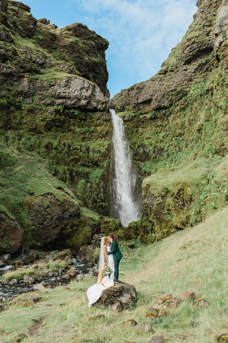Joana and Kili celebrating their wedding in Iceland in front of an epic private waterfall during their elopement 