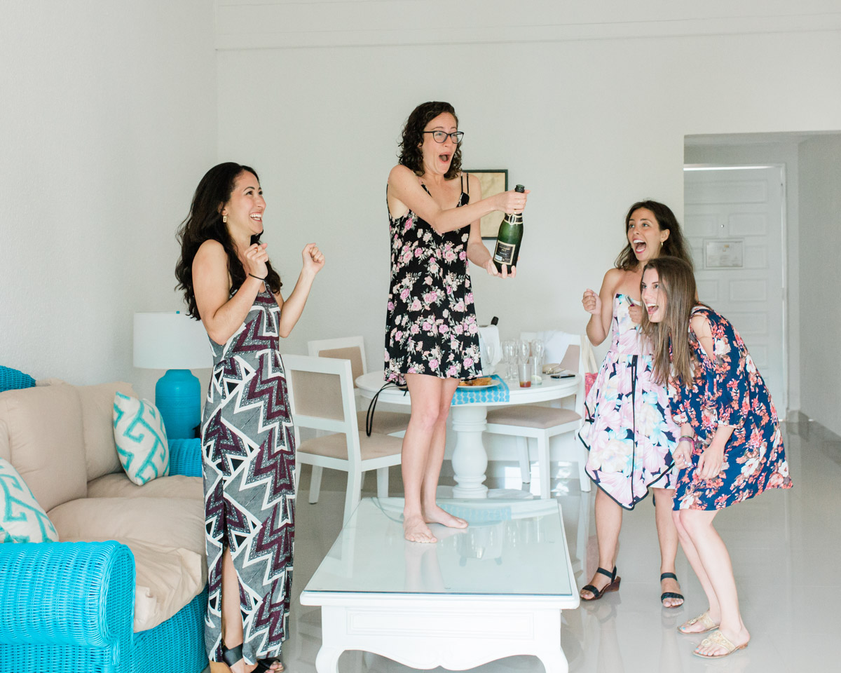 A bride with her girls getting ready laughing and having a blast before she gets married and has an intimate Dominican Republic destination wedding