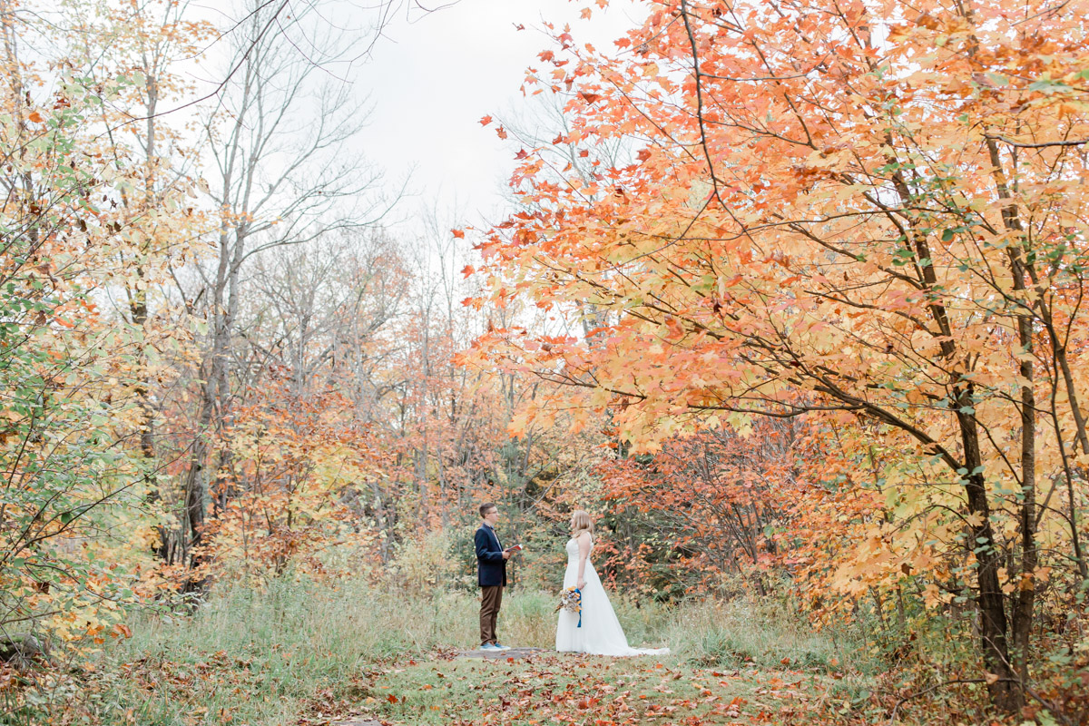 A couple saying there vows in the middle of Autumn in Muskoka in Ontario Canada elopement 