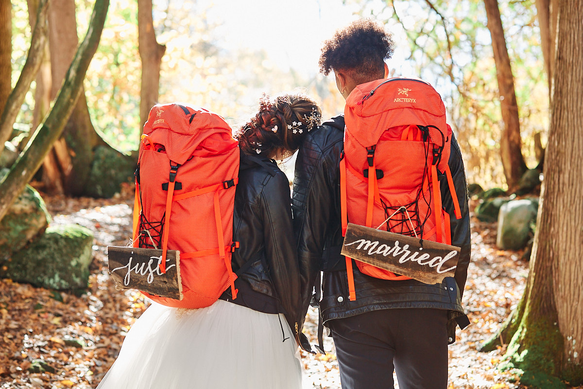 A couple about to have a short hike for their elopement with their just married camping backpacks. She is sweetly putting her head on his shoulder. They had a beautiful intimate elopement at a private airbnb close to Prince Edward County in Ontario