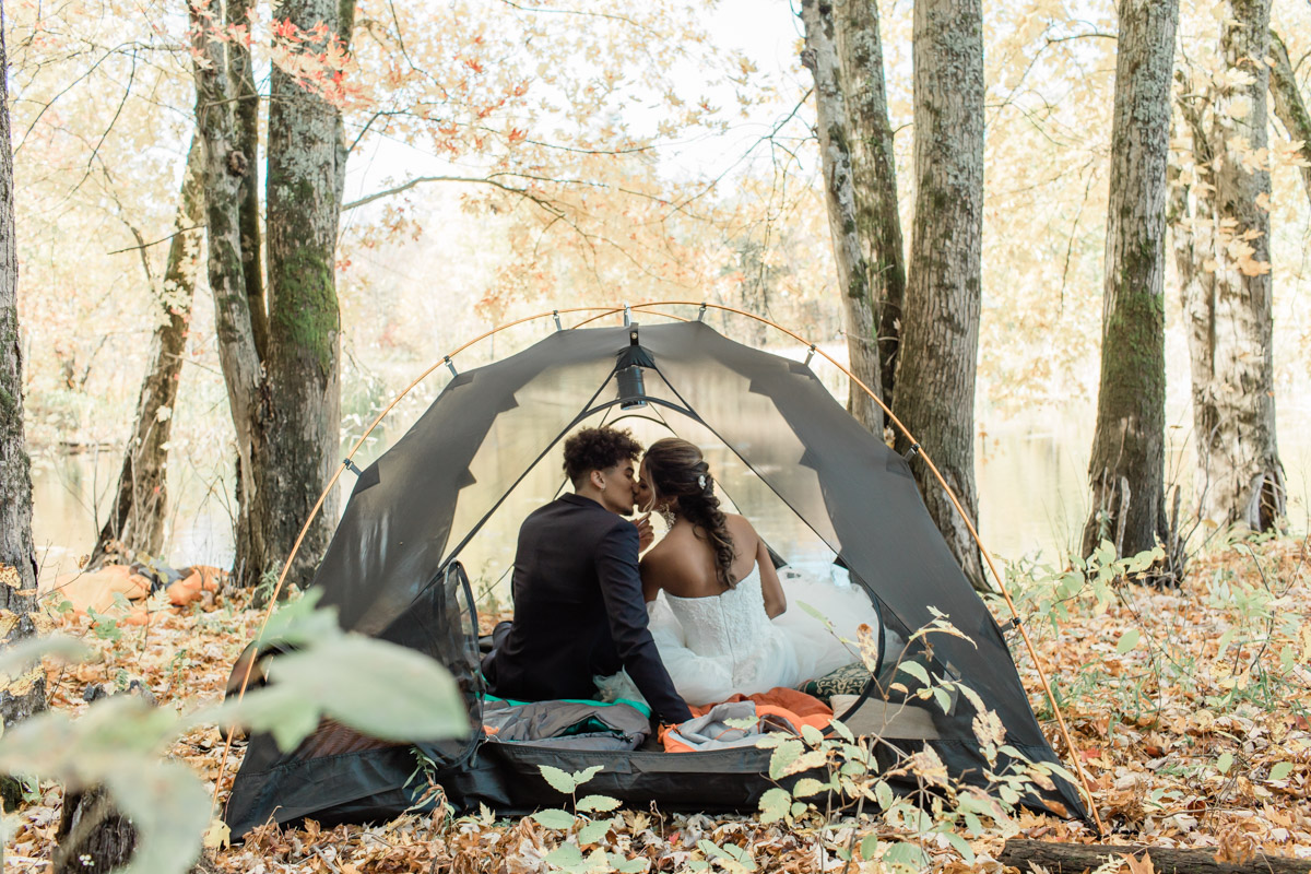 A couple enjoying a romantic moment in their tent during their private camping elopement. 