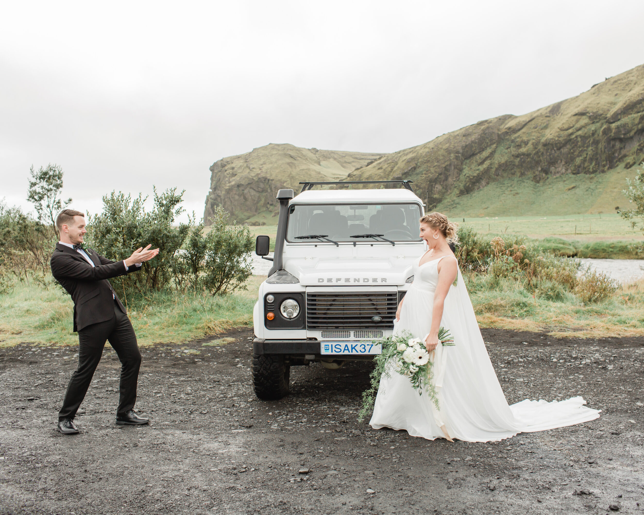 A man admires his soon to be wife near a 4x4 during their first look.