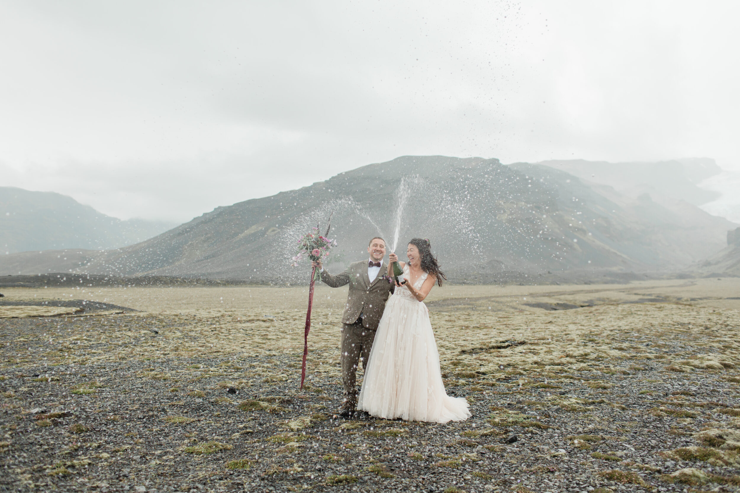 A couple celebrates their Iceland elopement with champagne.