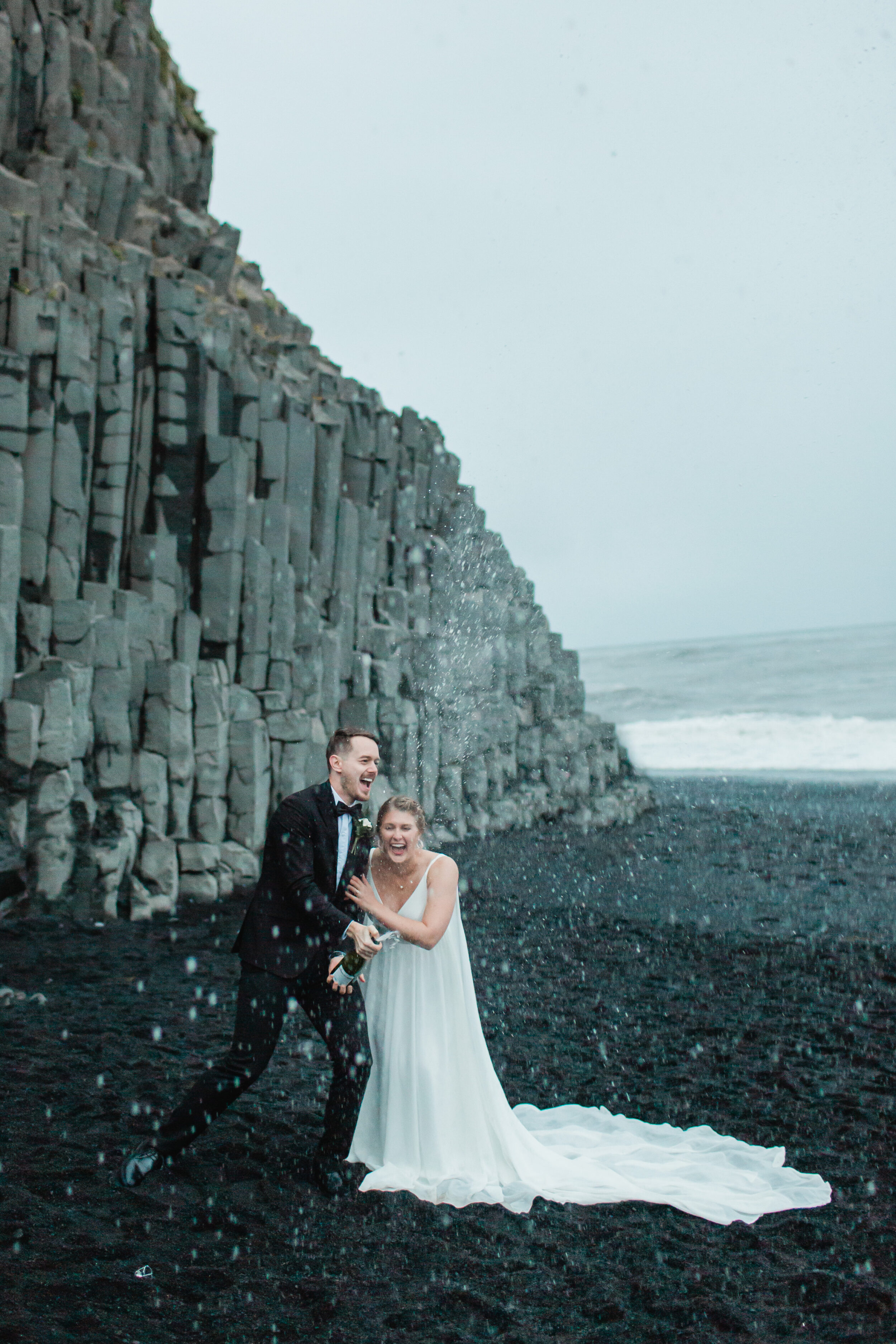 A couple pops champagne in celebration of their beautiful Iceland wedding ceremony.