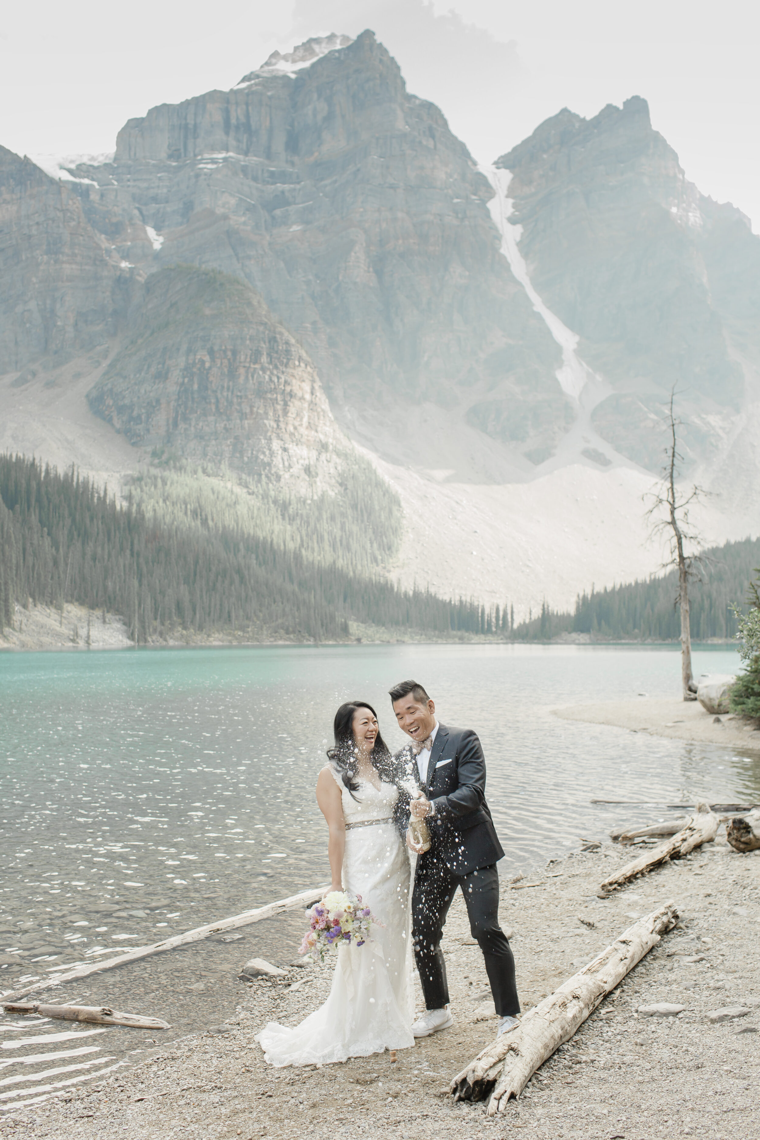 A couple pops champagne in celebration of their wedding in the Canadian Rockies.