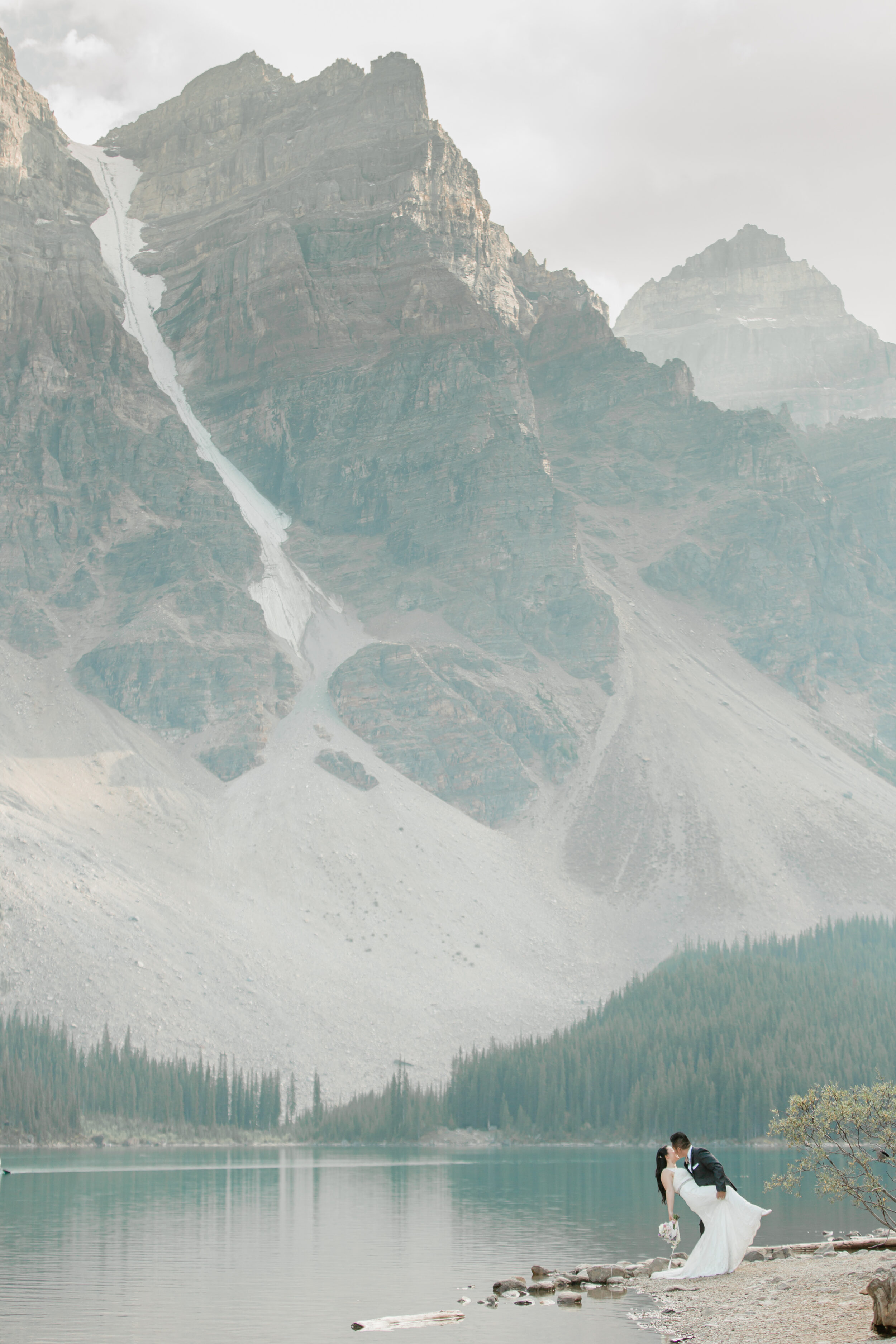 A couple poses with the Canadian Rockies in the background for their Banff elopement.