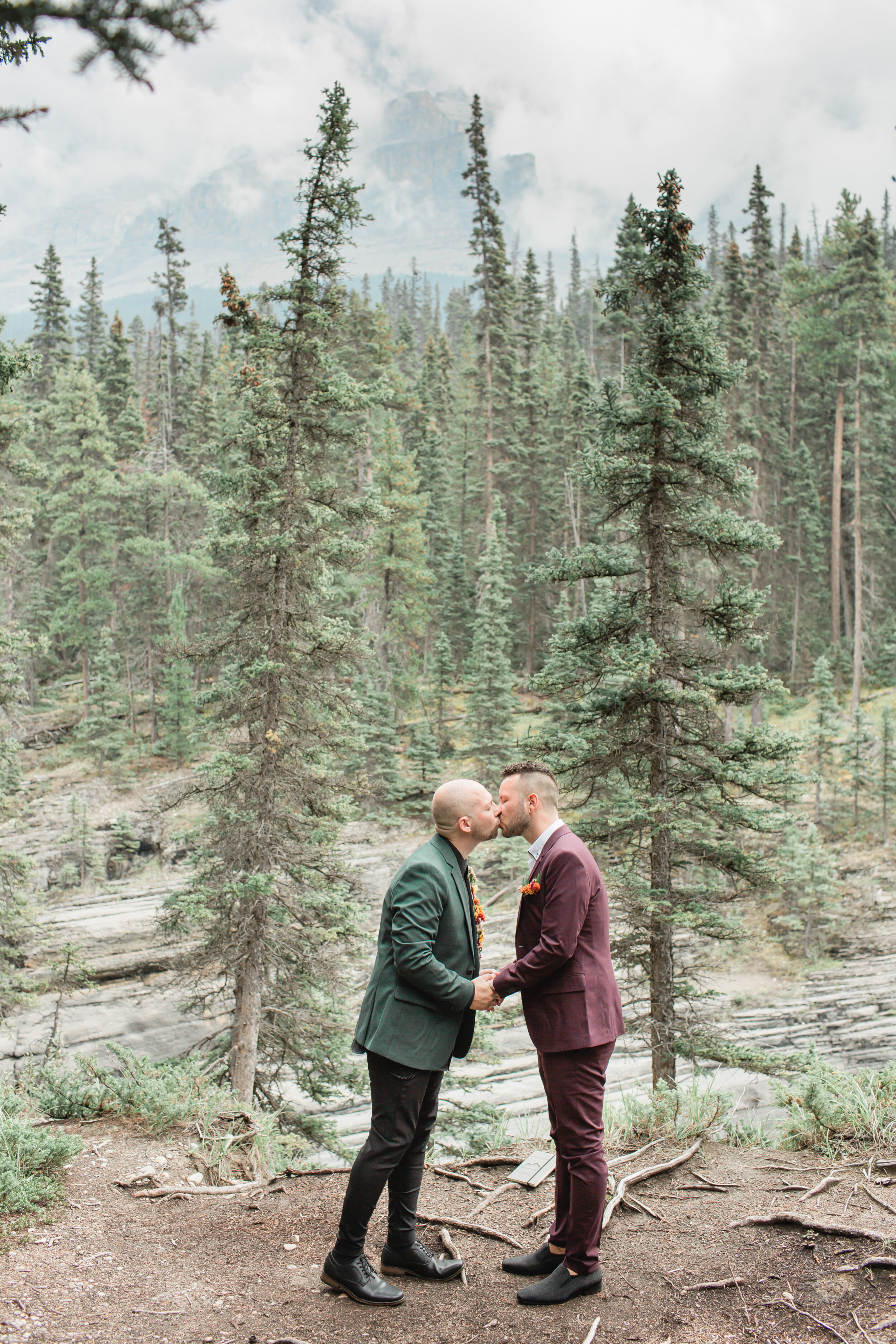 A couple shares a kiss after saying wedding vows during their Alberta elopement in Banff.