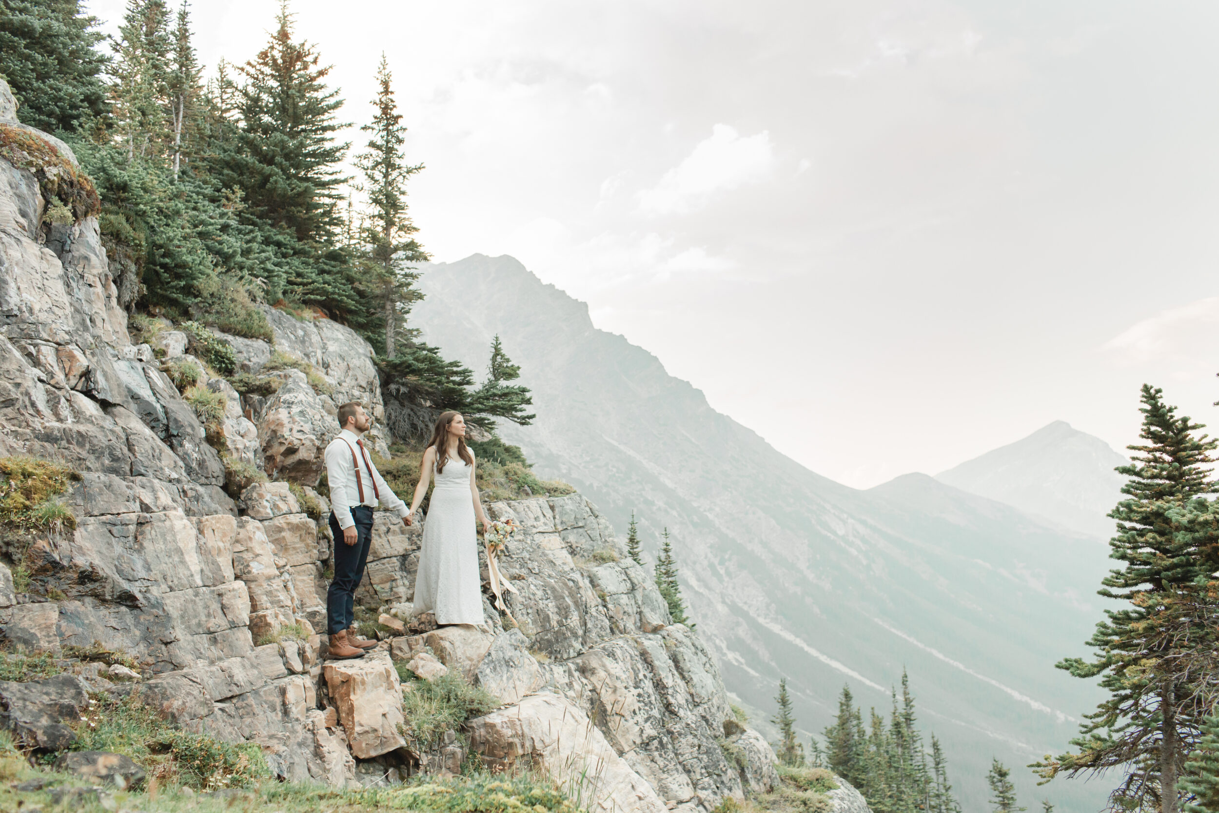 A couple stands on an overlook for their wedding portraits in Banff National Park.