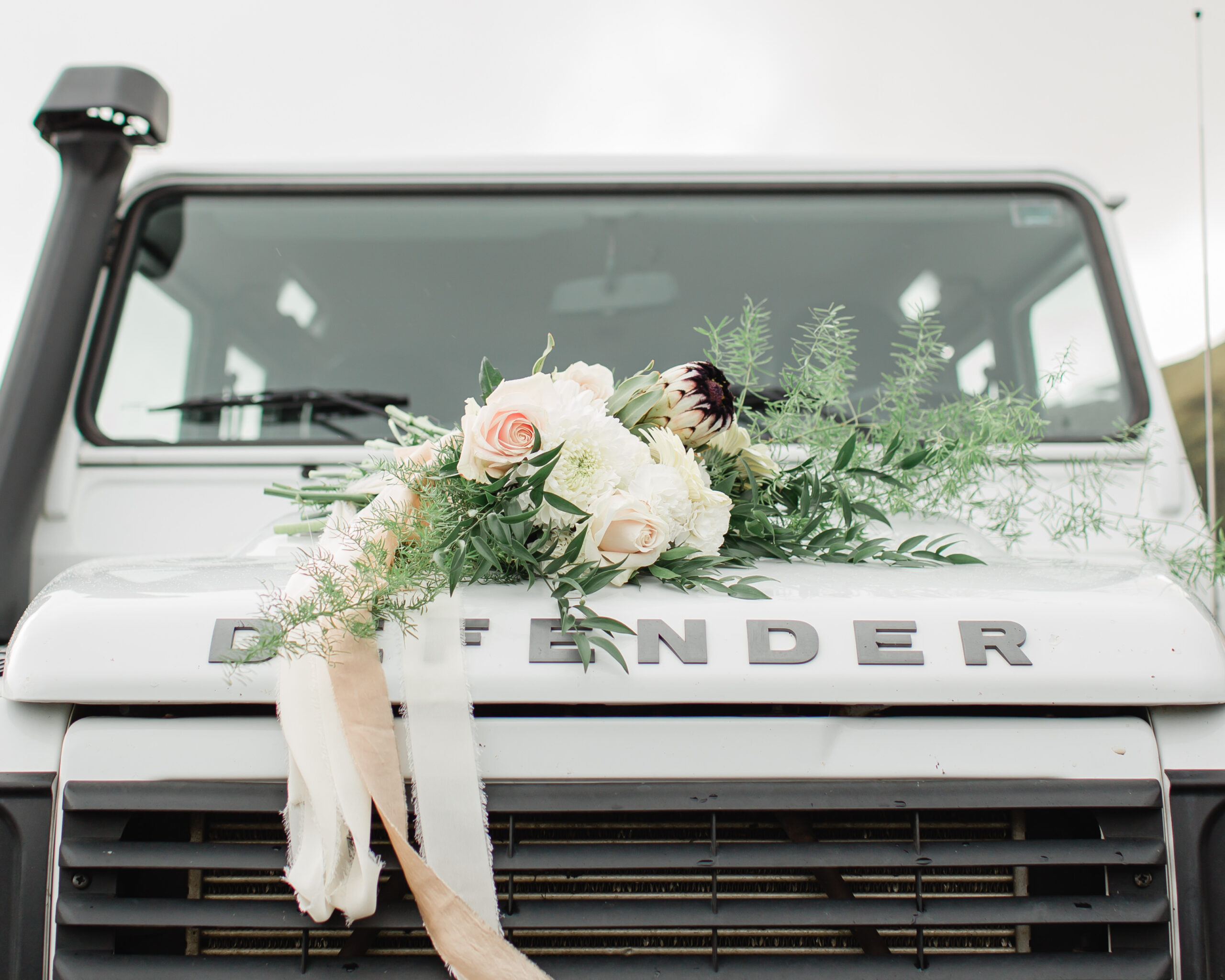A detail shot of a wedding bouquet sitting atop a Defender in Iceland.