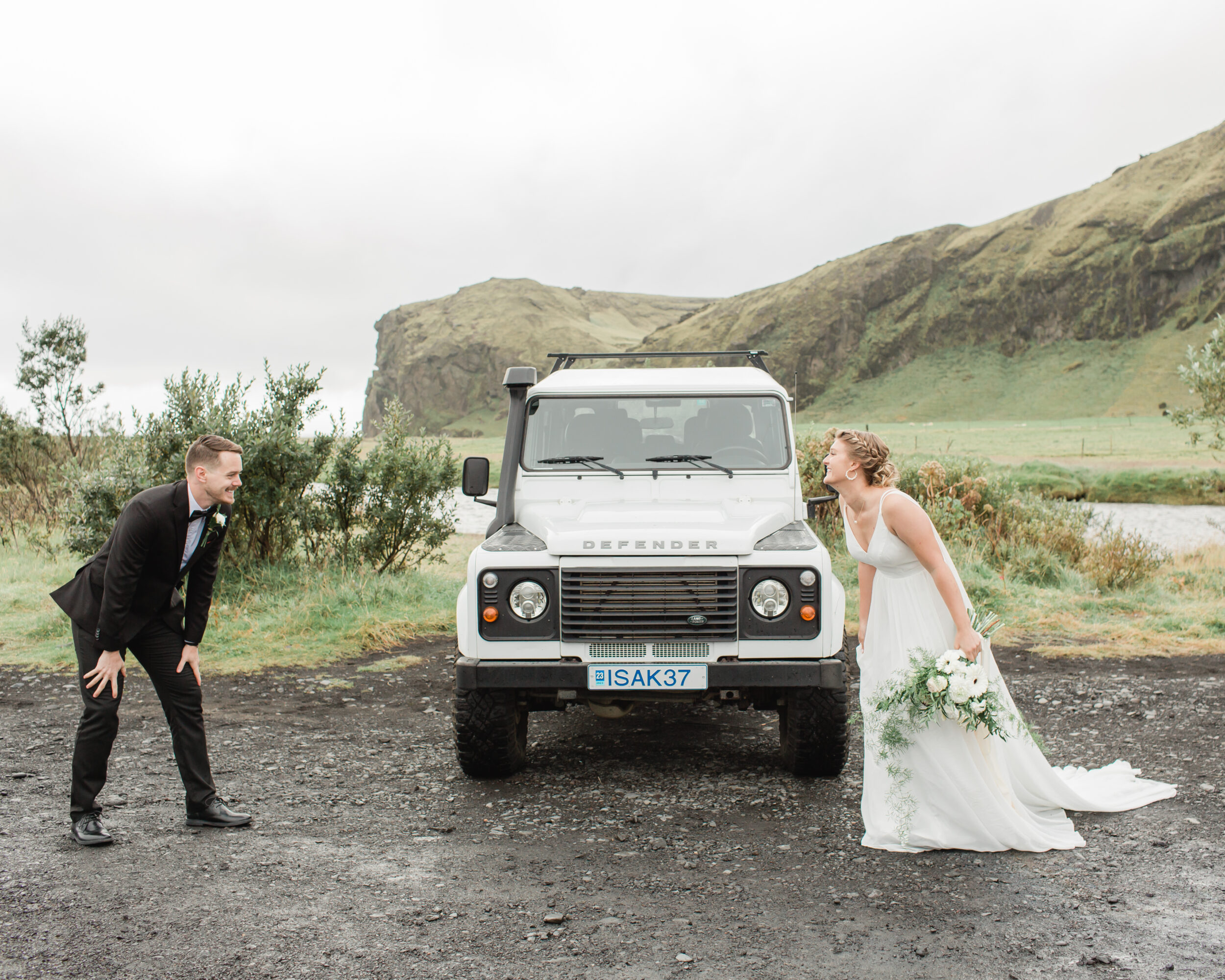 A couple celebrates their first look in front of a Defender in Iceland.