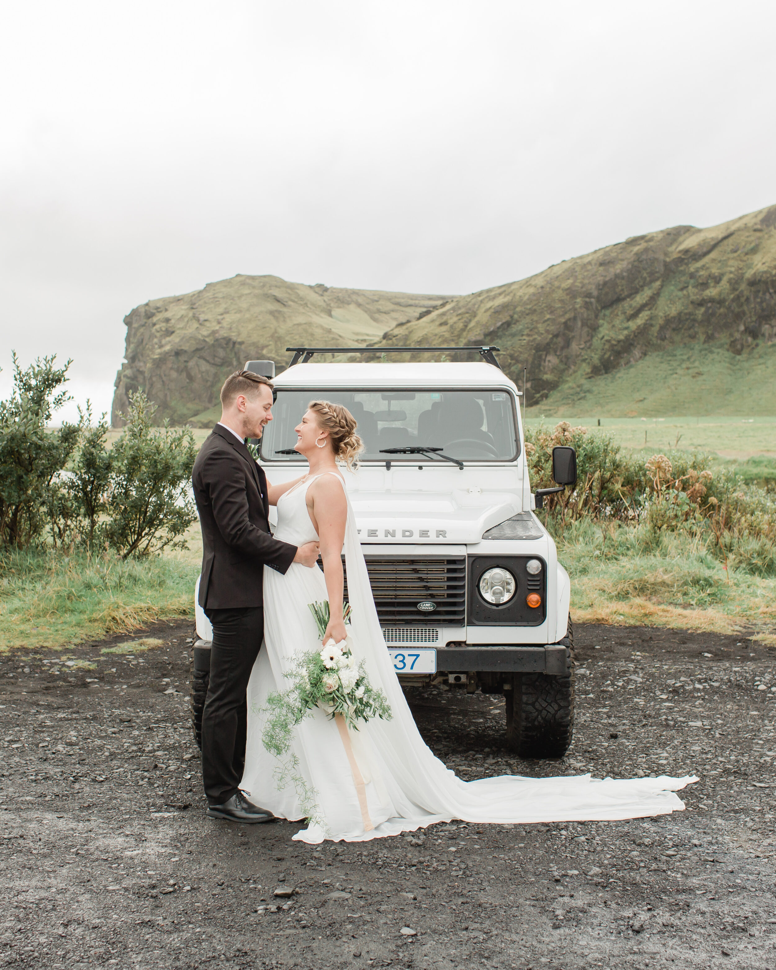 A couple admires one another before their adventure elopement by a waterfall in Iceland. 
