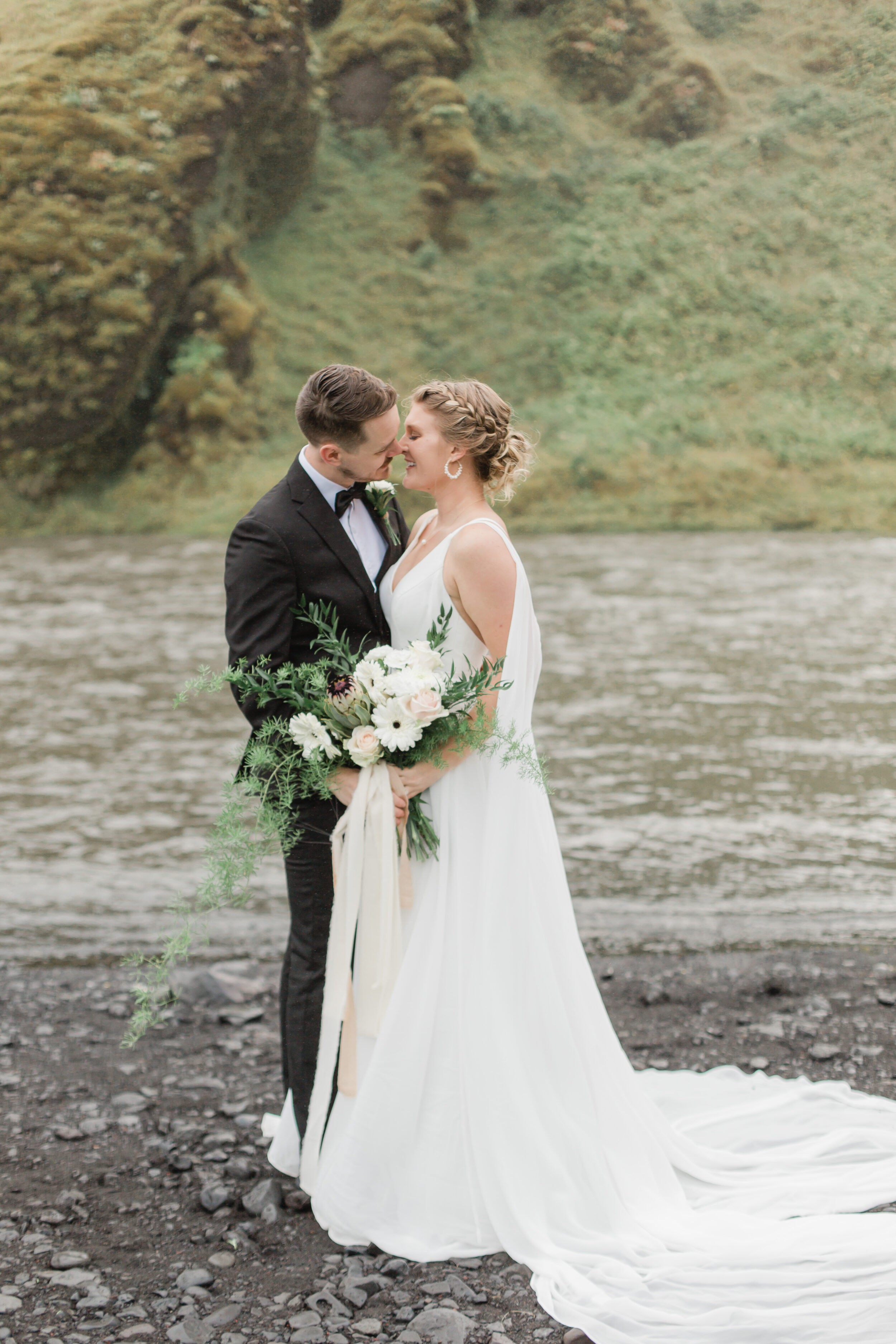 A couple kisses near an Icelandic stream during their elopement. 