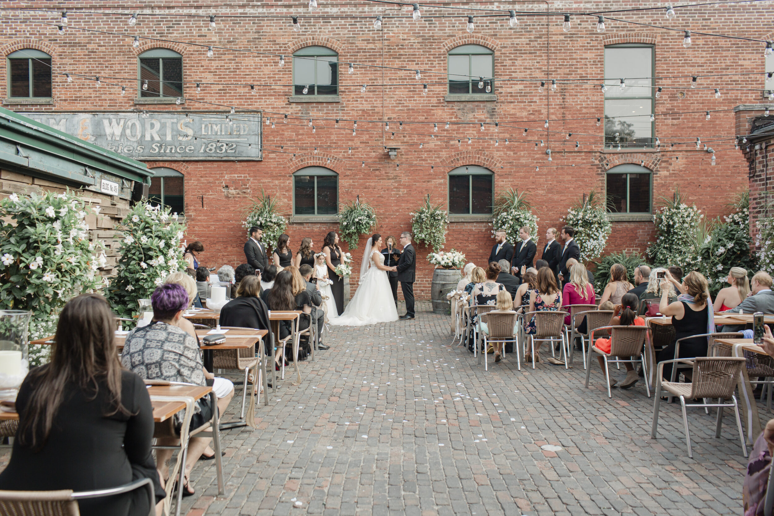 A couple gets married against a brick wall backdrop in Toronto. 