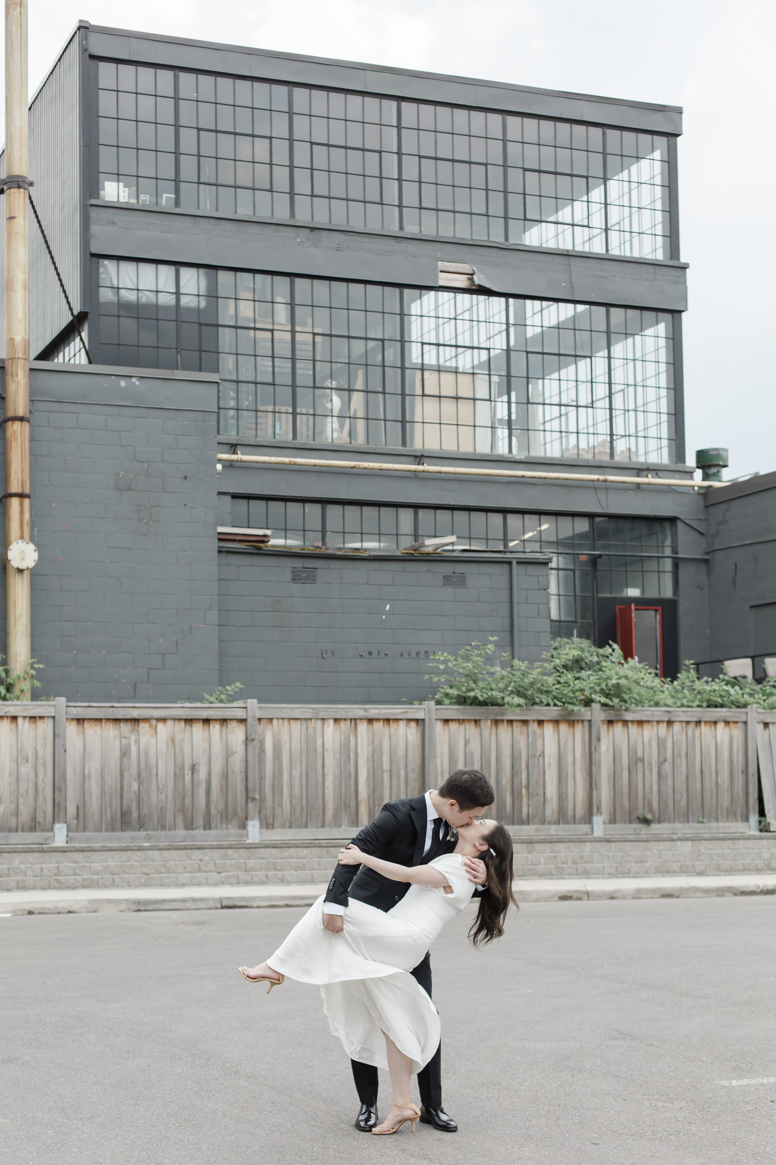 A man dips his bride in downtown Toronto for wedding portraits. 