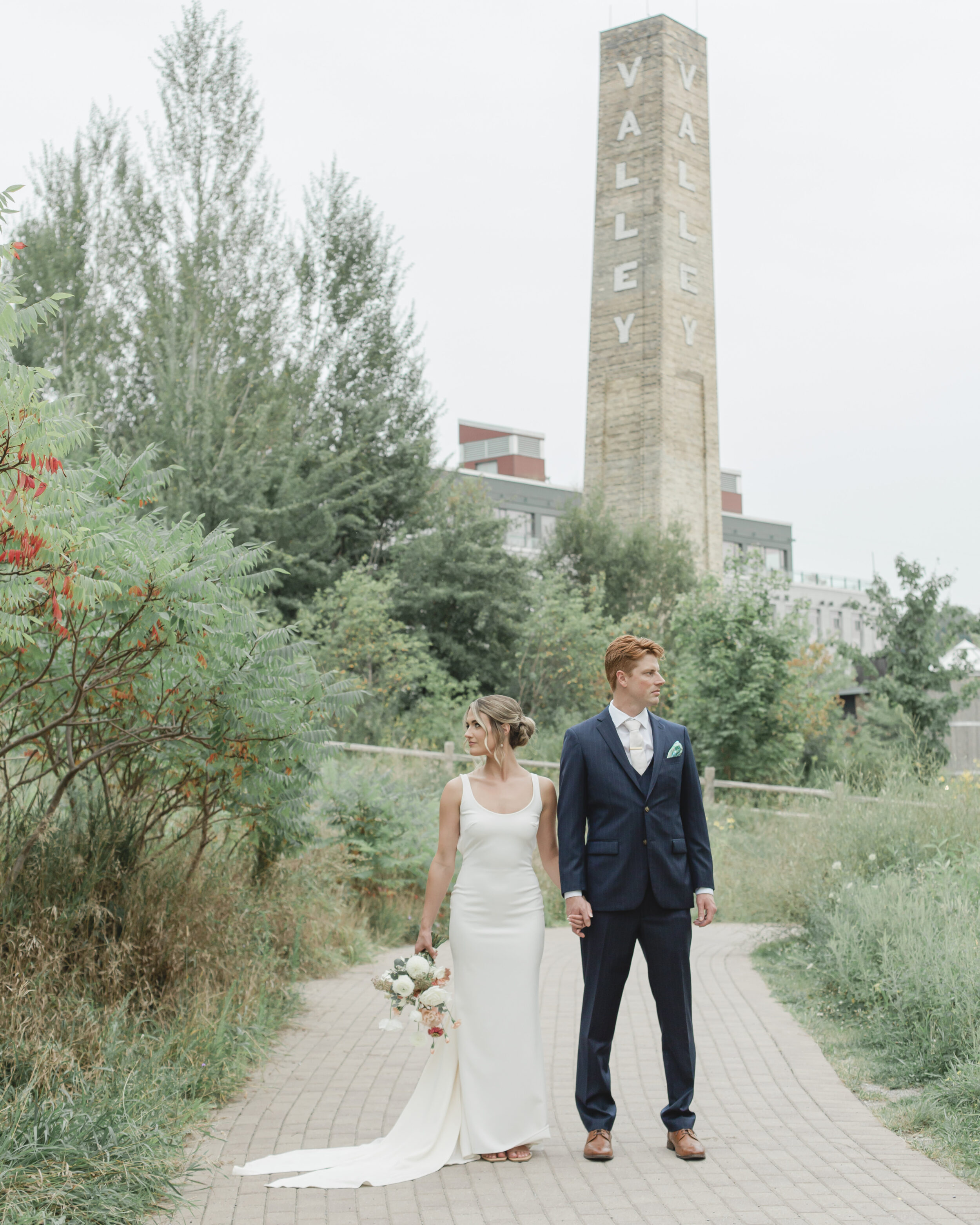 A couple sands in front of Evergreen Brick Words during their elopement in Toronto.