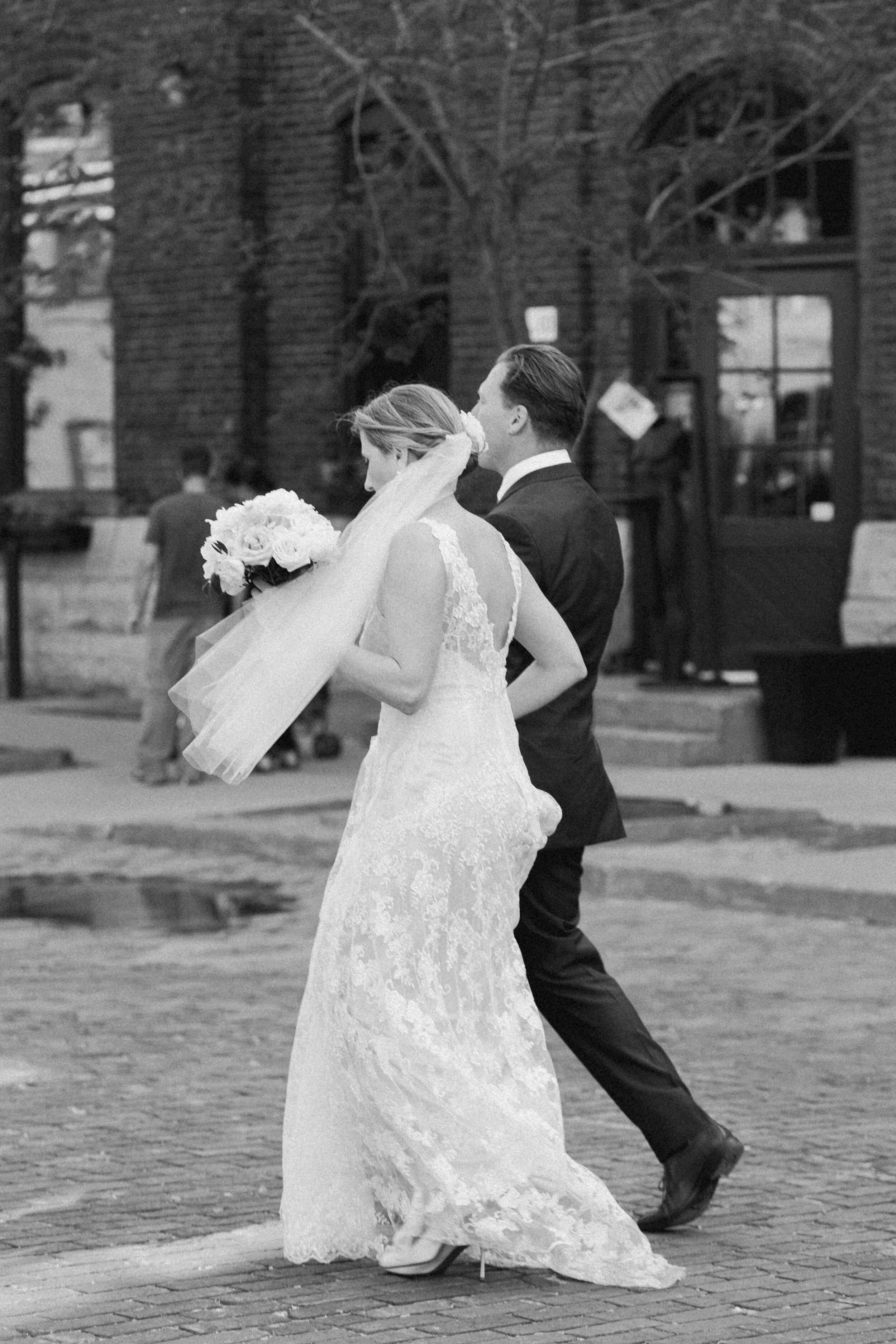 A couple walks across a Toronto city street during their urban elopement.