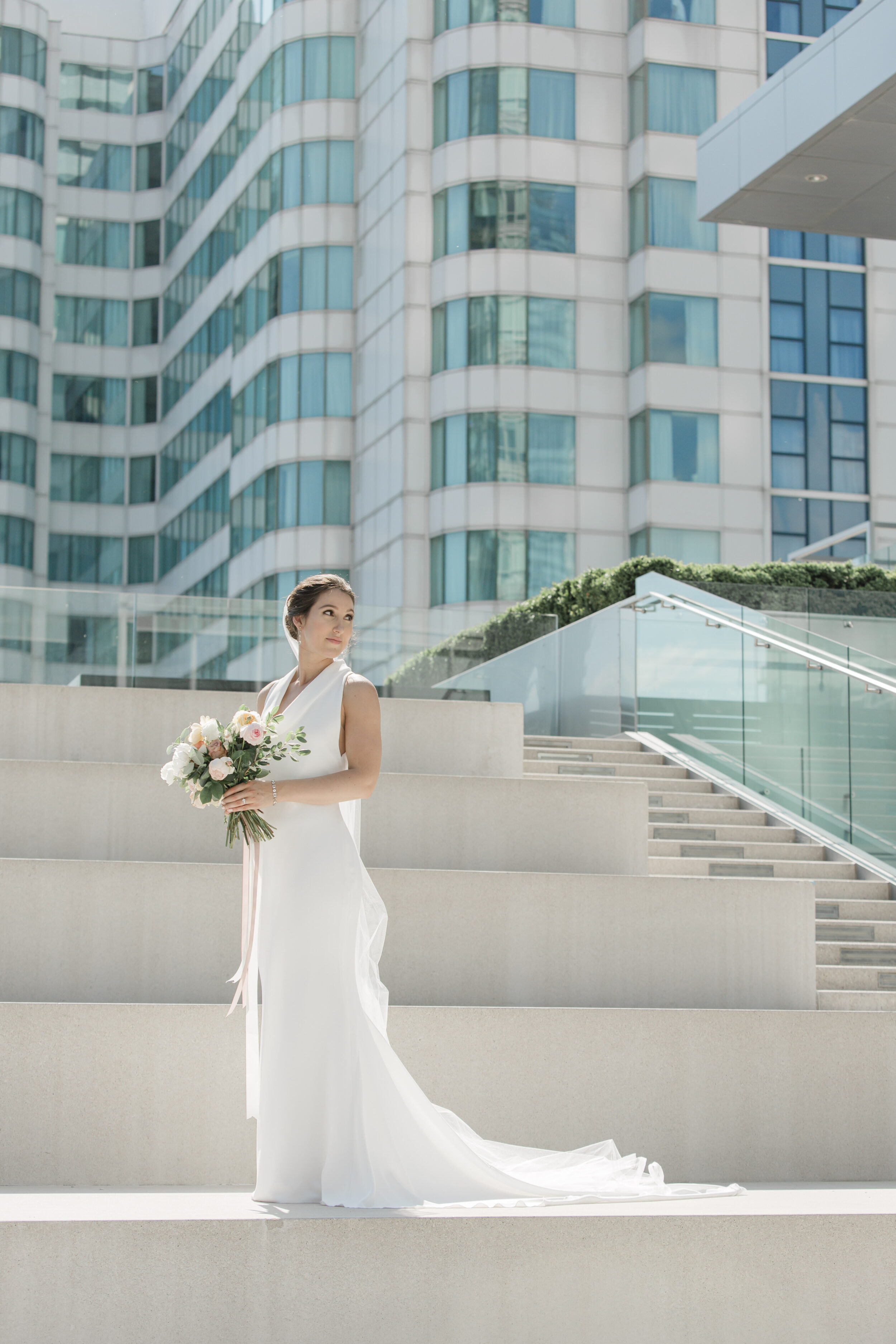 A bride stands on a luxurious Toronto hotel staircase while taking bridal portraits for her wedding. 