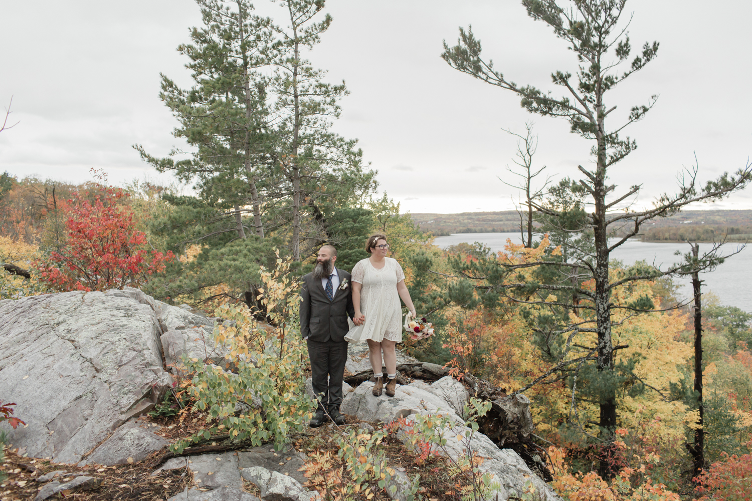 A couple looking at the view after their elopement ceremony on Manitoulin Island in autumn 