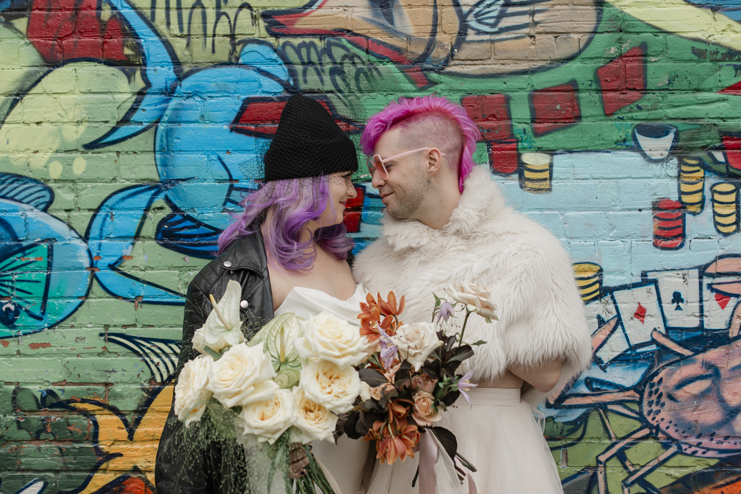 A couple romantically looking into each other's eyes during their elopement portraits in Toronto at Graffiti alley 
