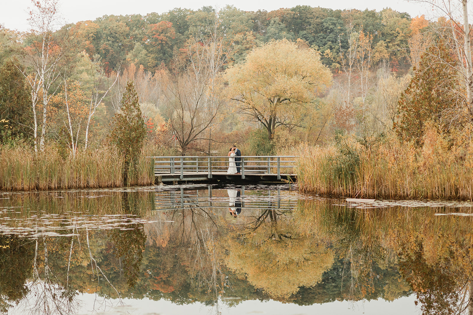 A couple kissing after their Toronto wedding at Evergreen Brick Works during the autumn season 
