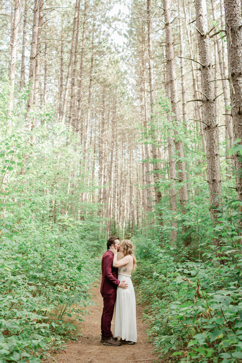 Walking along the trail hand in hand towards their ceremony spot near the waterfalls along the high falls trail in Algonquin's southgate for their Ontario elopement 