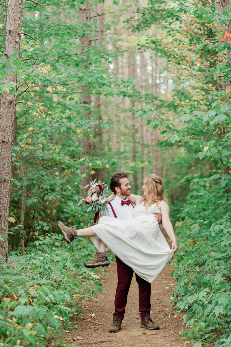 Walking along the trail hand in hand towards their ceremony spot near the waterfalls along the high falls trail in Algonquin's southgate for their Ontario elopement 