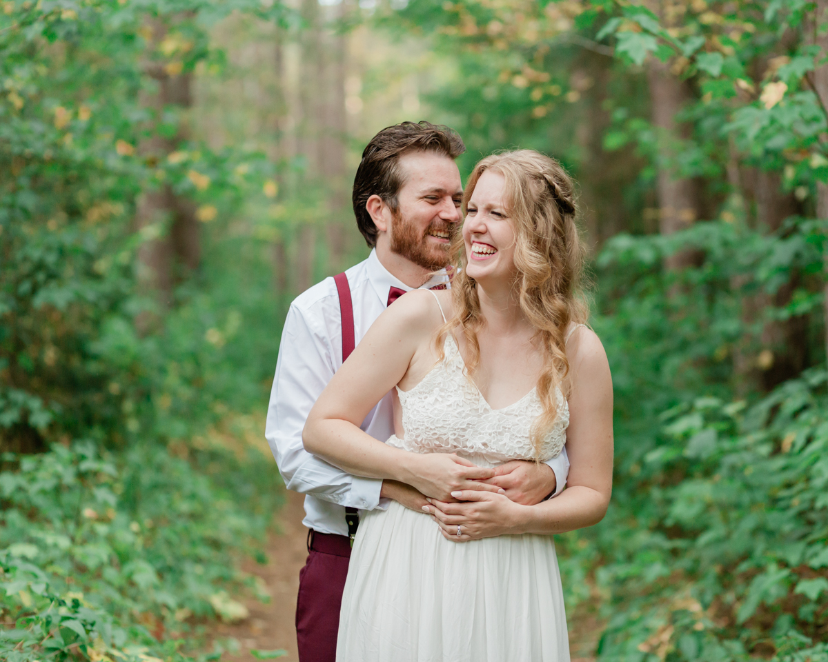 A couple laughing during their wedding portraits 
