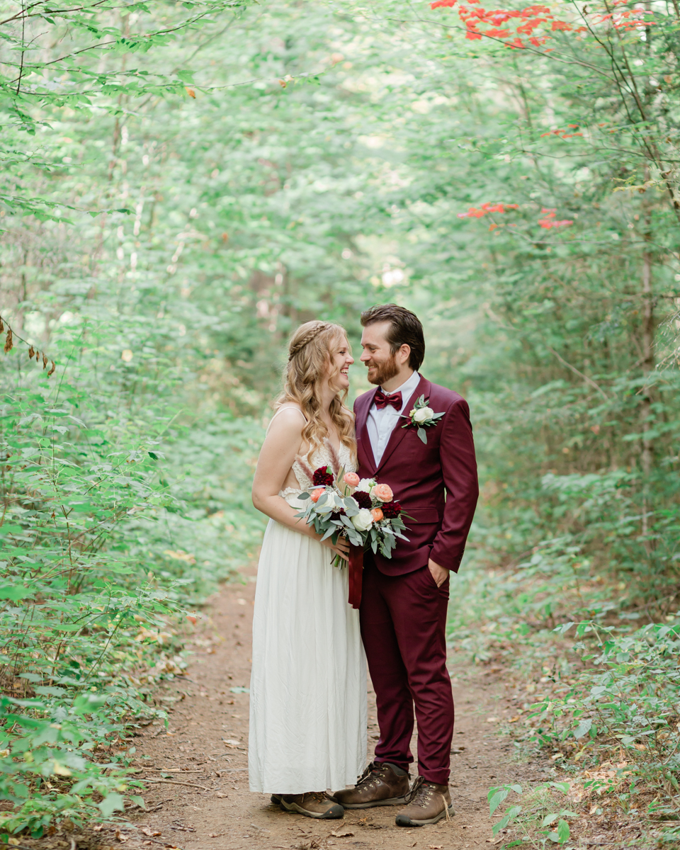 Walking along the trail hand in hand towards their ceremony spot near the waterfalls along the high falls trail in Algonquin's southgate for their Ontario elopement 