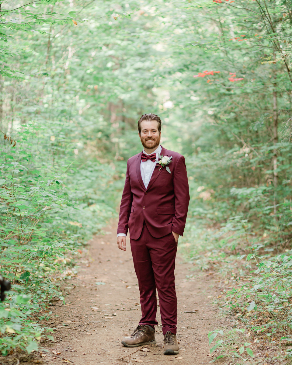 Walking along the trail hand in hand towards their ceremony spot near the waterfalls along the high falls trail in Algonquin's southgate for their Ontario elopement 