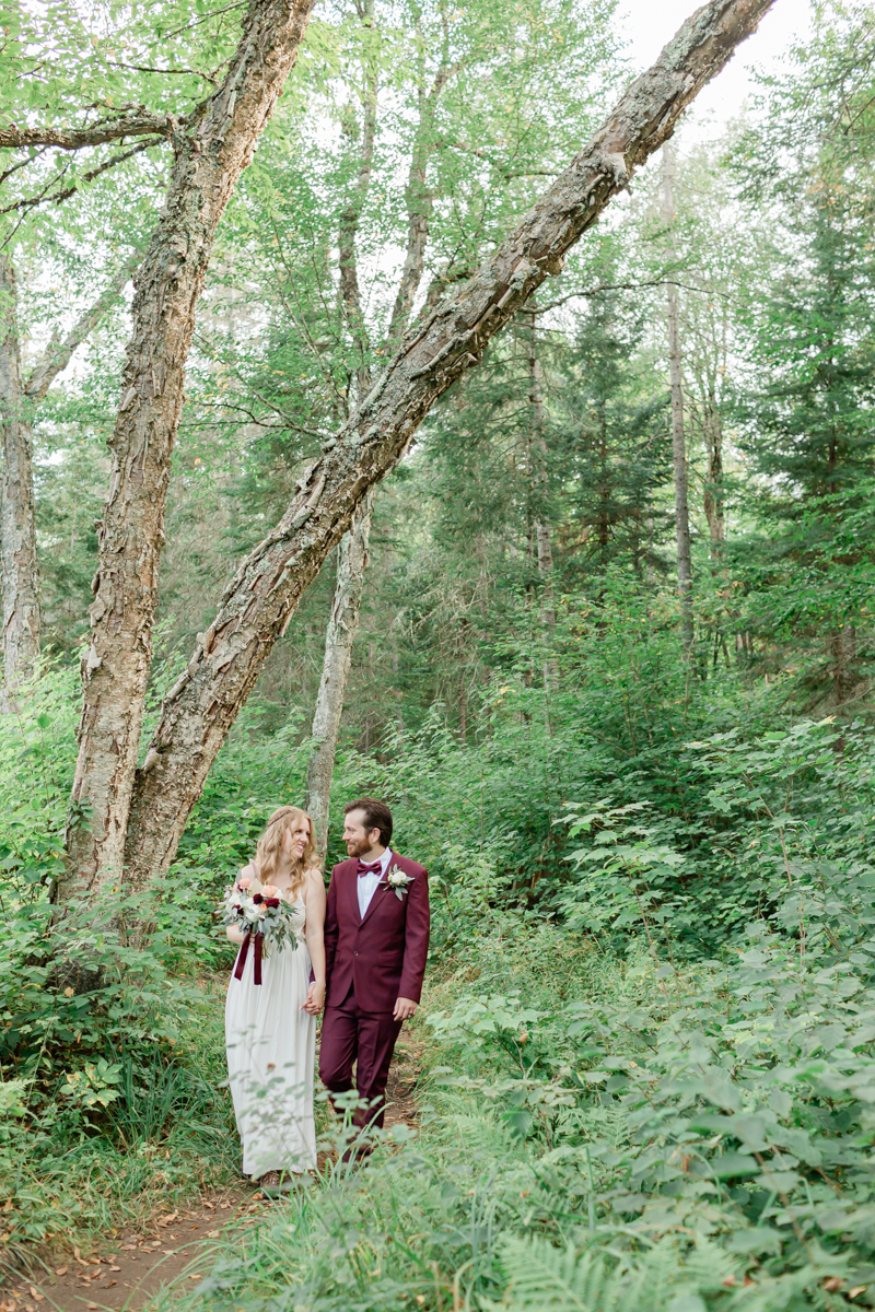 Walking along the trail hand in hand towards their ceremony spot near the waterfalls along the high falls trail in Algonquin's southgate for their Ontario elopement 