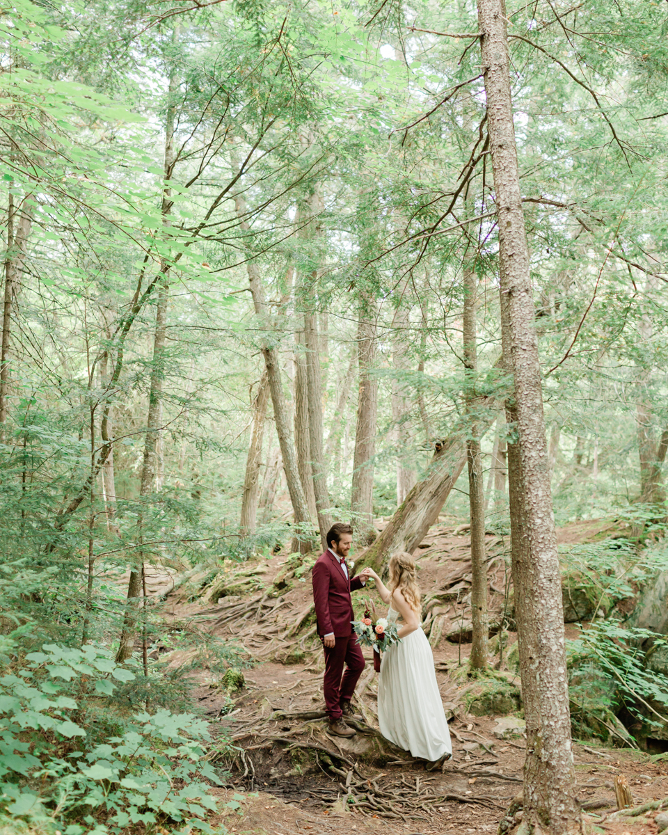 Walking along the trail hand in hand towards their ceremony spot near the waterfalls along the high falls trail in Algonquin's southgate for their Ontario elopement 