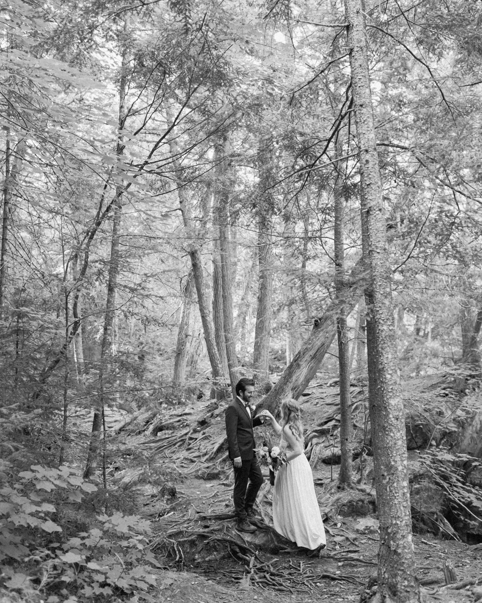 Walking along the trail hand in hand towards their ceremony spot near the waterfalls along the high falls trail in Algonquin's southgate for their Ontario elopement 