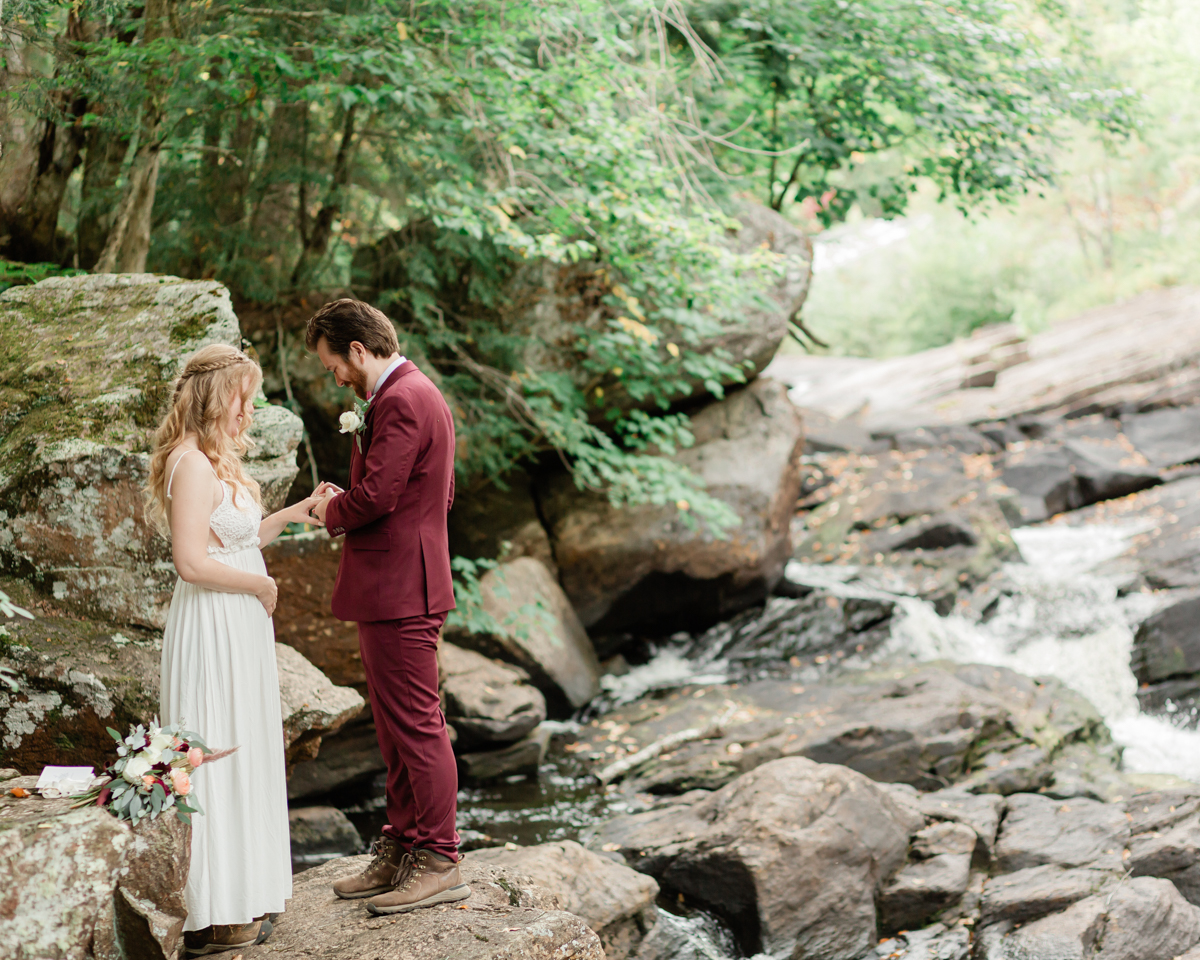 Chelsea and Kevin exchange rings and vows at High Falls for their Algonquin Park elopement in Ontario near Harcourt 