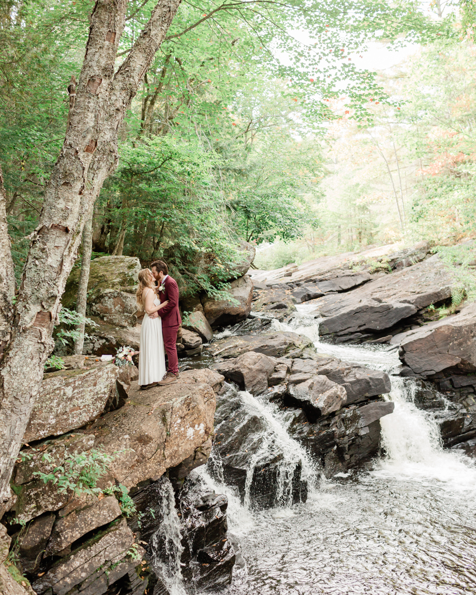 Chelsea and Kevin exchange rings and vows at High Falls for their Algonquin Park elopement in Ontario near Harcourt 