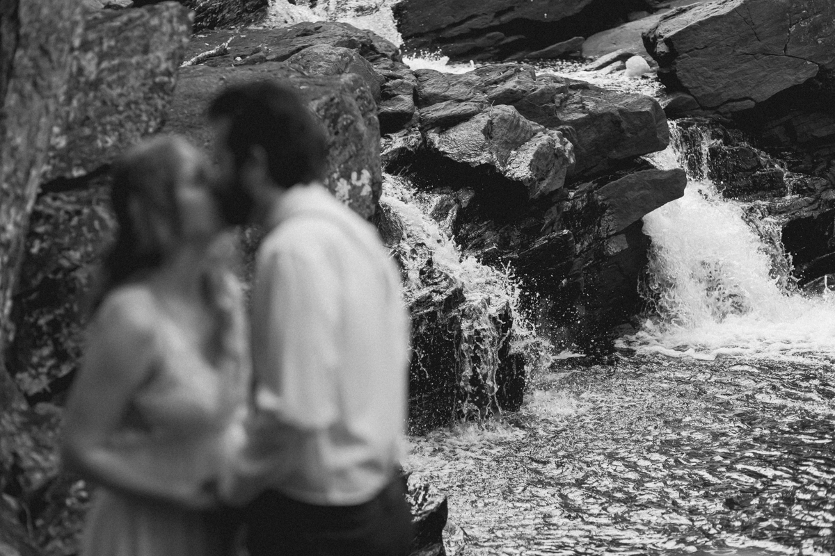 Chelsea and Kevin exchange rings and vows at High Falls for their Algonquin Park elopement in Ontario near Harcourt 