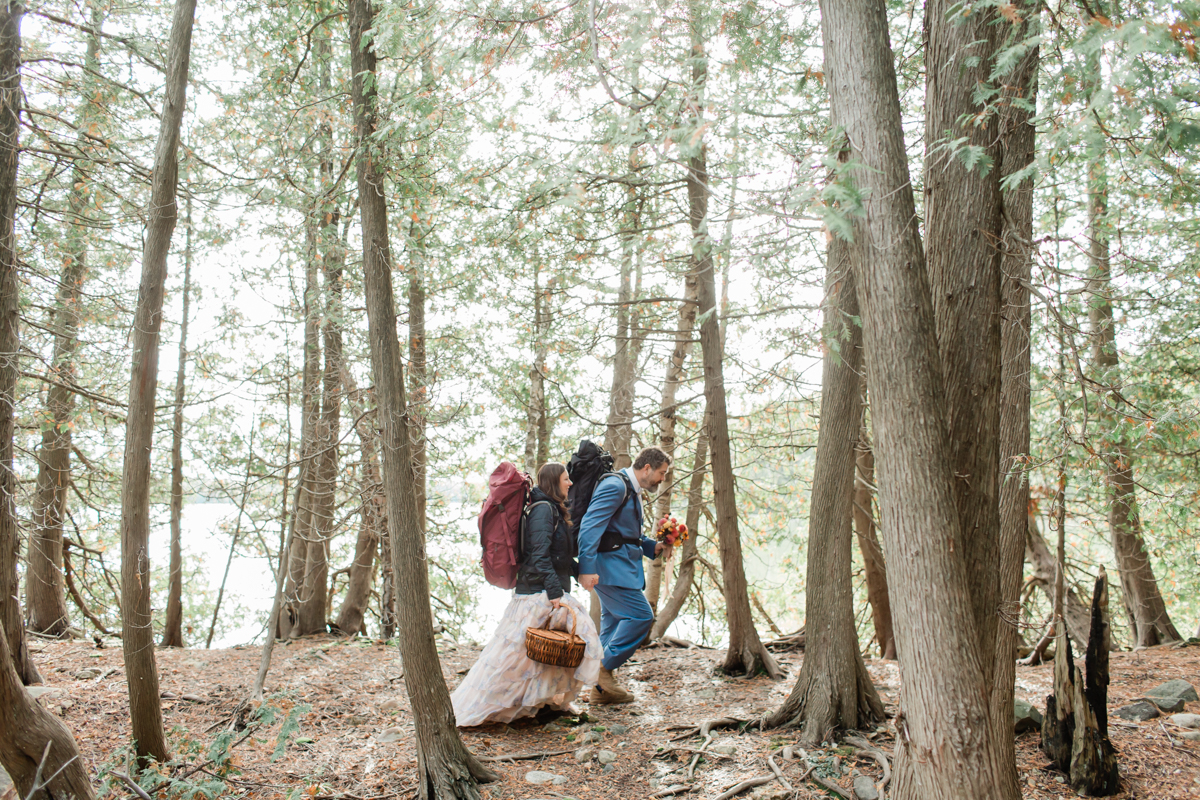 A couple hiking to their ceremony during their Ontario wedding