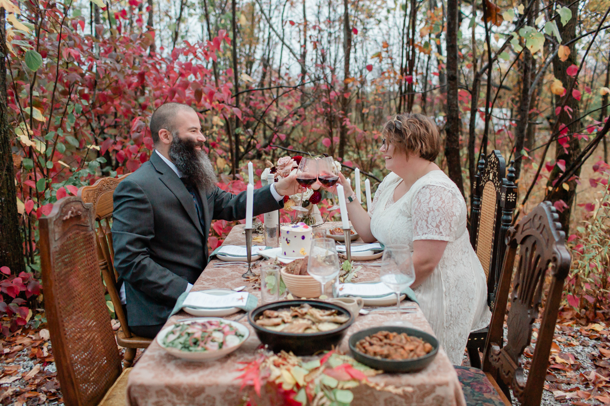 A couple laughing and eating a delicious catered dinner at their airbnb on Manitoulin island during their wedding 