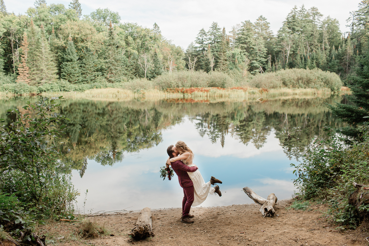 A couple kissing after their Algonquin Park elopement in front of a private lake
