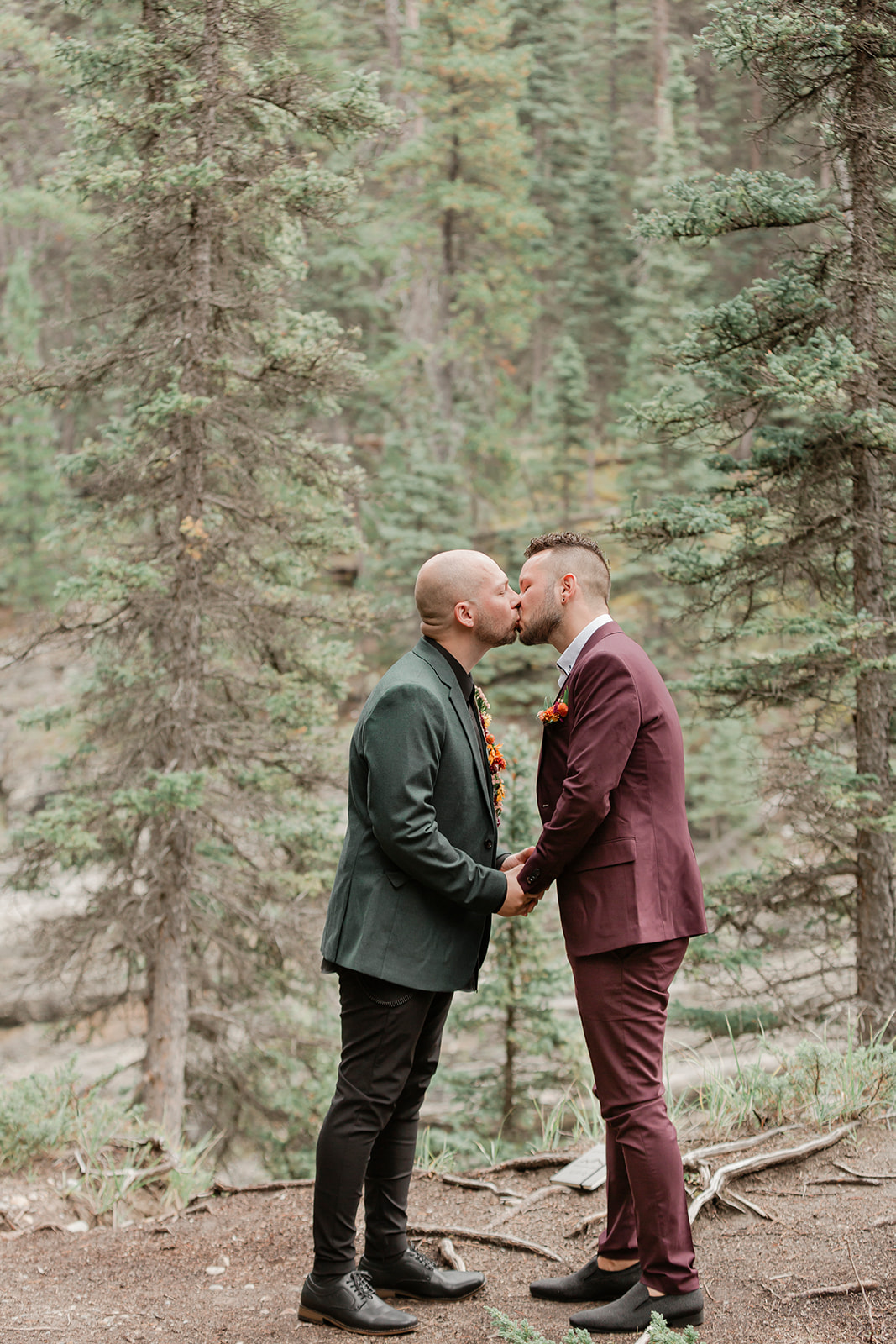 A Mistaya Canyon elopement couple kisses during an intimate outdoor vow ceremony near Banff.