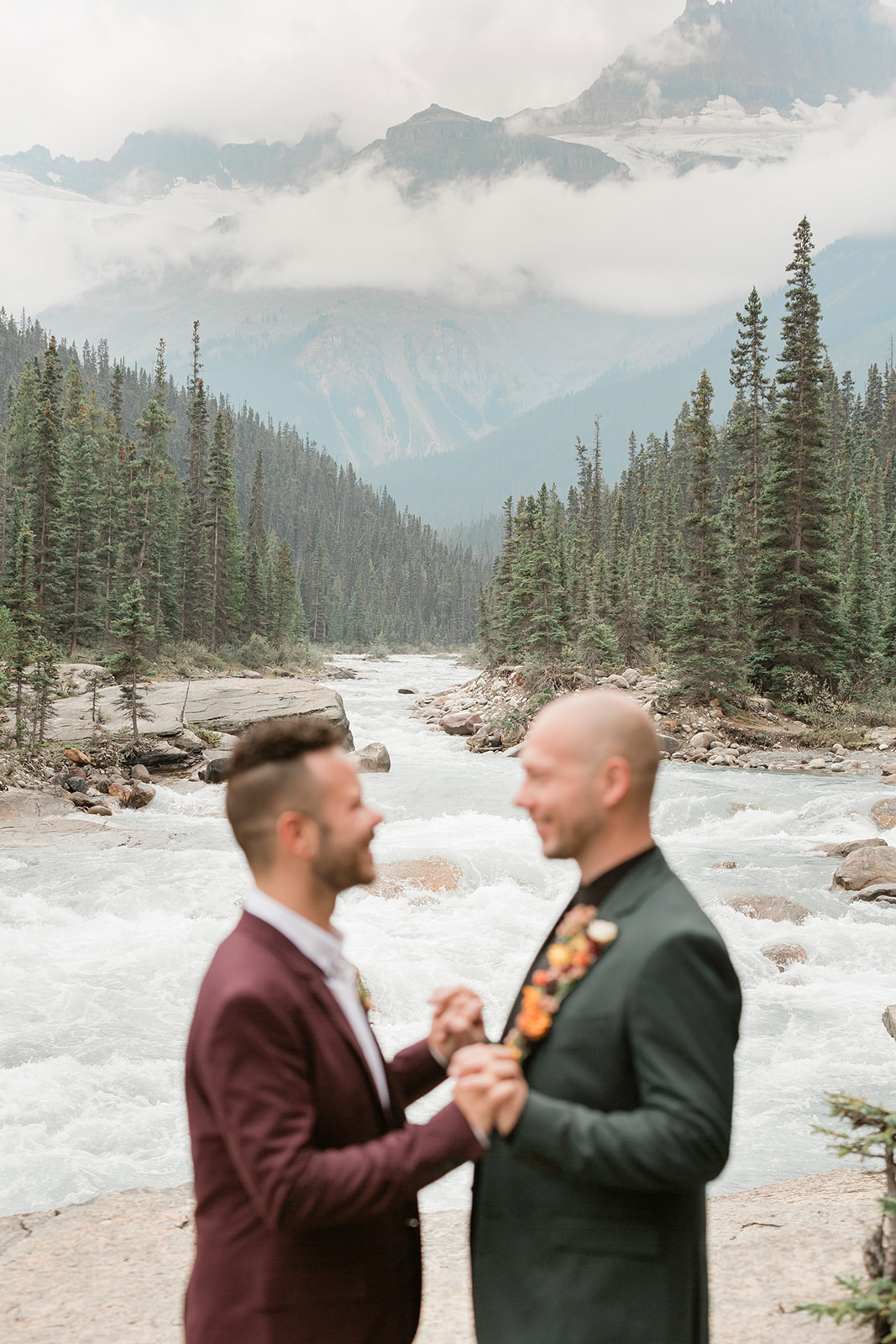 A Banff elopement couple holds hands with one another in an embrace near Mistaya Canyon. 