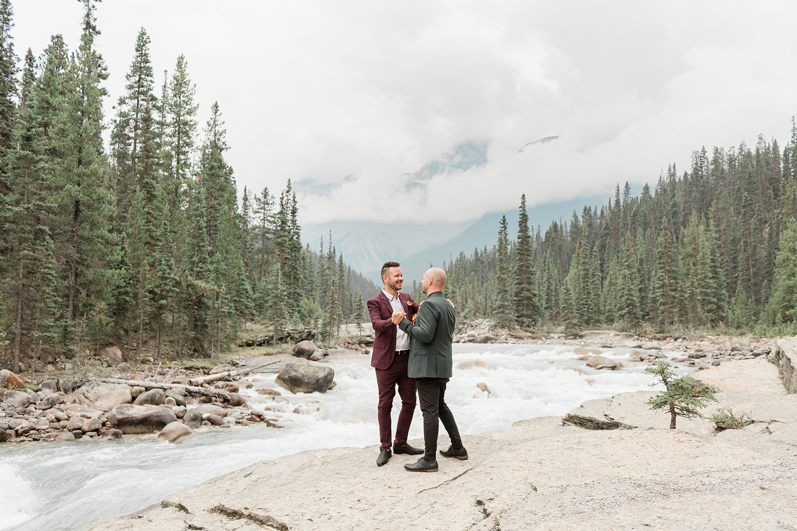 A Banff elopement couple dances on a rock formation near Mistaya Canyon.