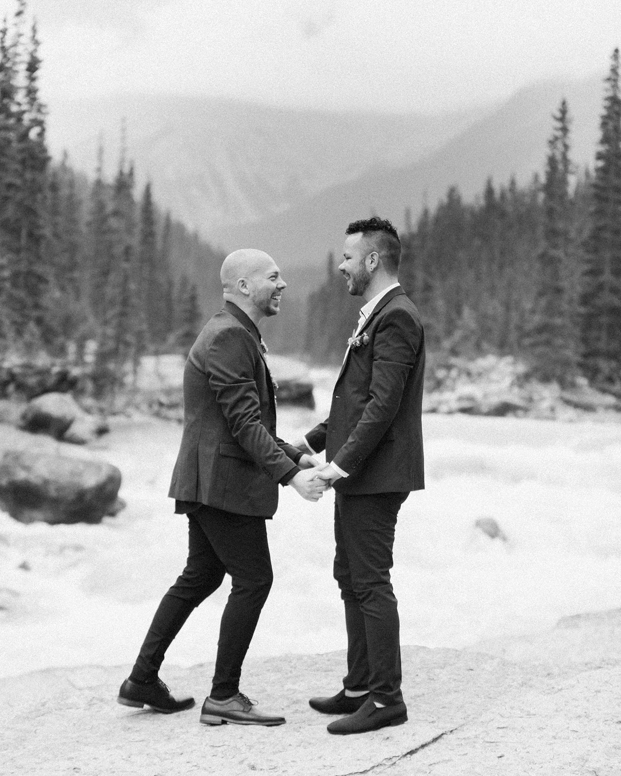 An adventure elopement couple holds hands near Mistaya Canyon during their intimate wedding ceremony. 