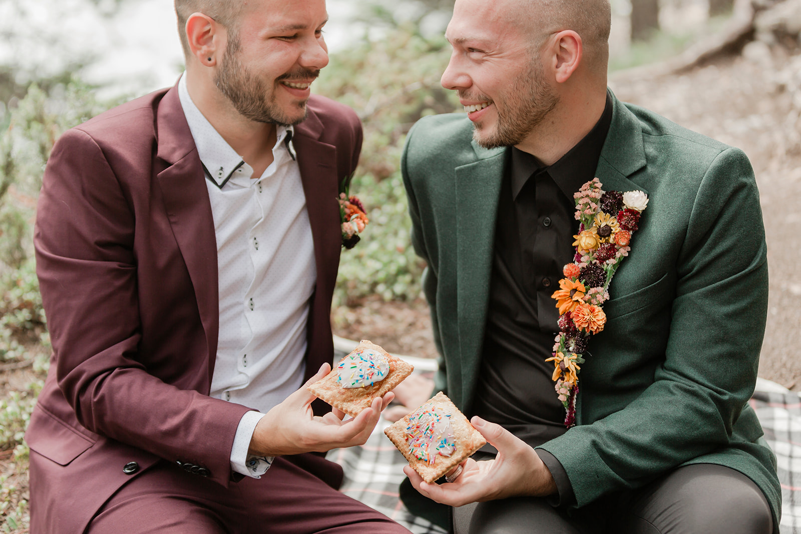 Grooms share pastries during a picnic  for their Mistaya Canyon elopement.