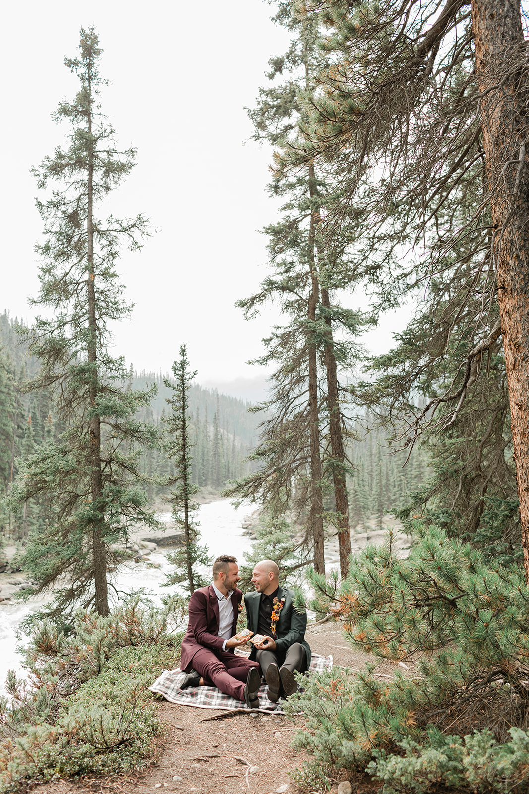 A Mistaya Canyon elopement couple enjoys pastries during a breakfast picnic near Banff.