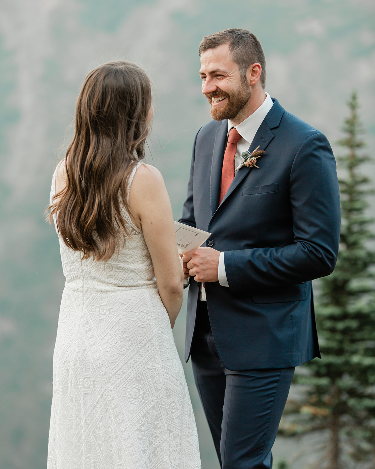 A groom recites vows to his bride during their Banff helicopter elopement ceremony. 