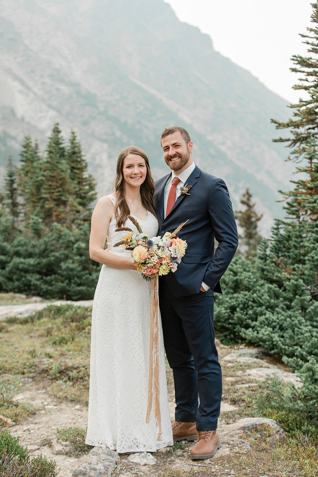 A Banff elopement couple smiles during their outdoor wedding portraits. 