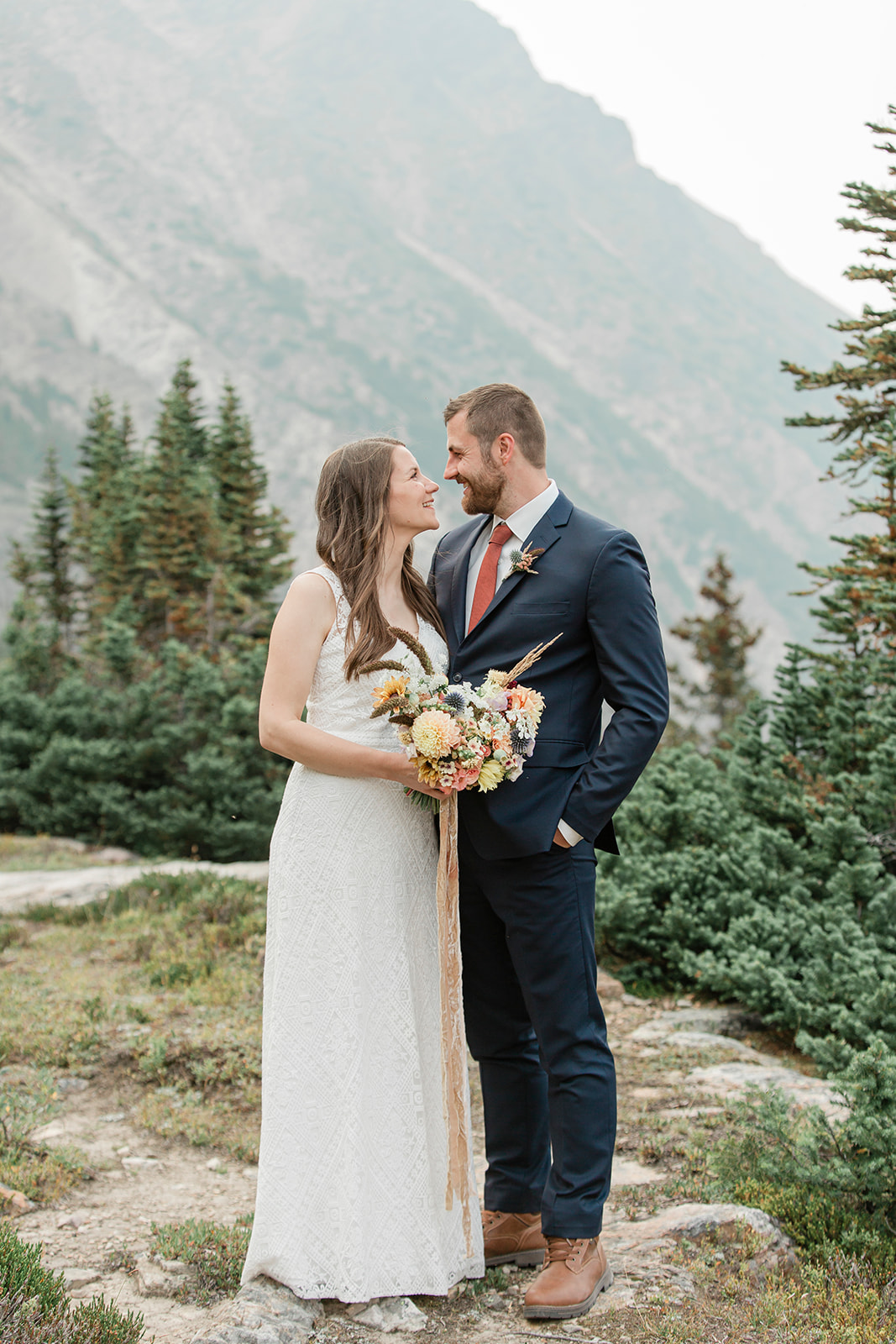 A Banff elopement couple admires one another during their outdoor wedding portraits. 