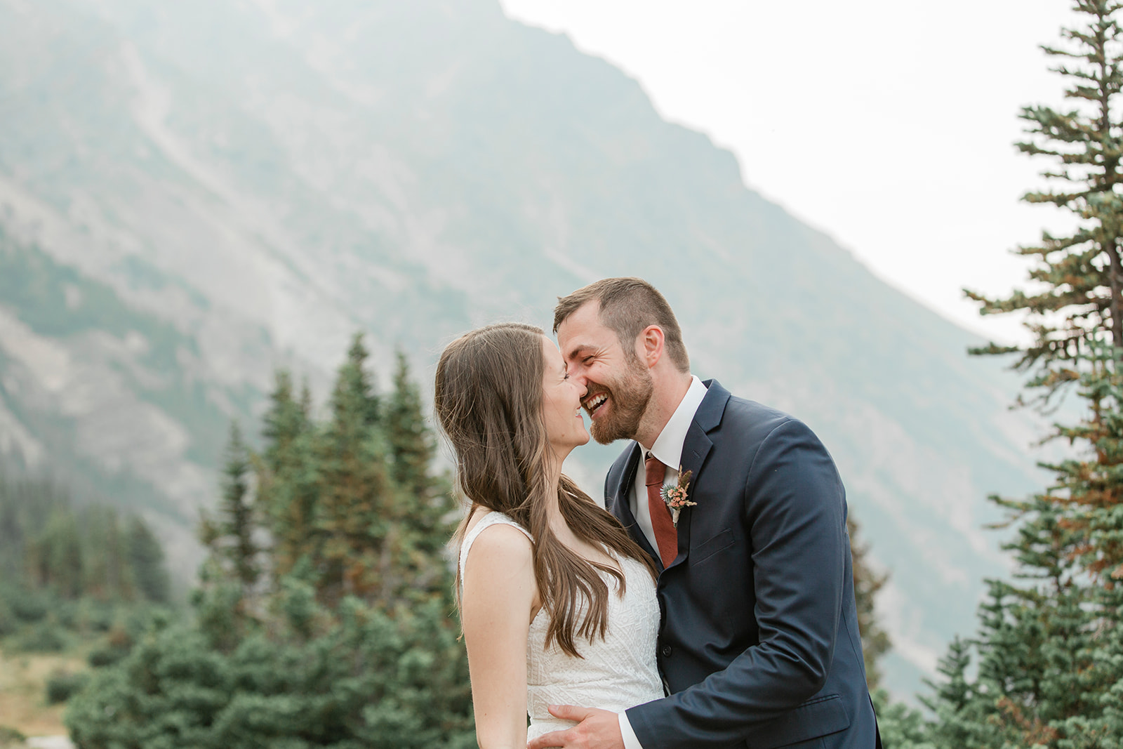 A Banff elopement couple shares a laugh with one another during their outdoor wedding portraits. 