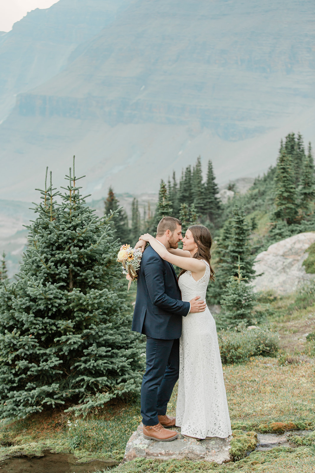 A Banff elopement couple embraces during their outdoor ceremony in Alberta. 