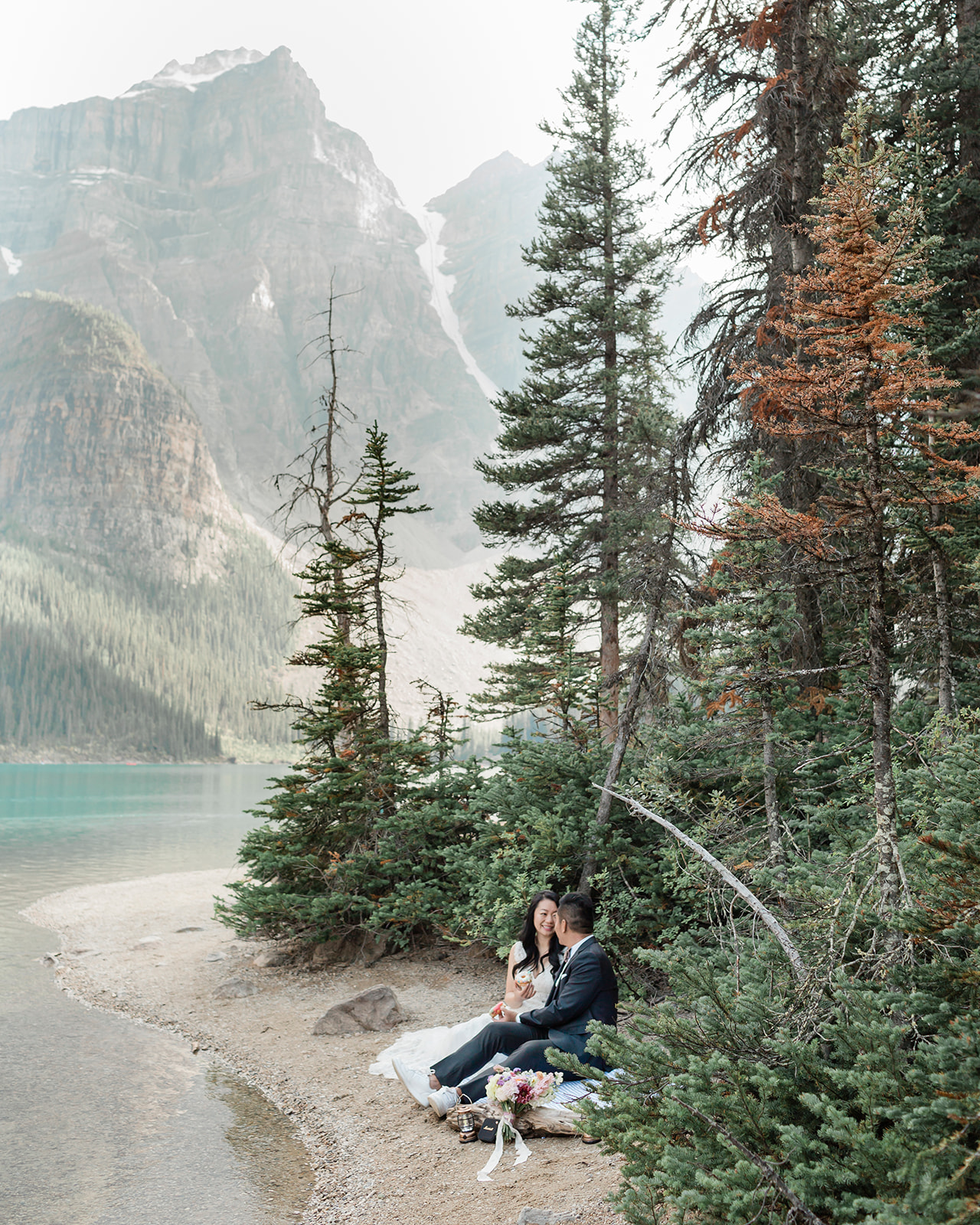 A couple shares donuts at a picnic during their sustainable wedding in Banff.